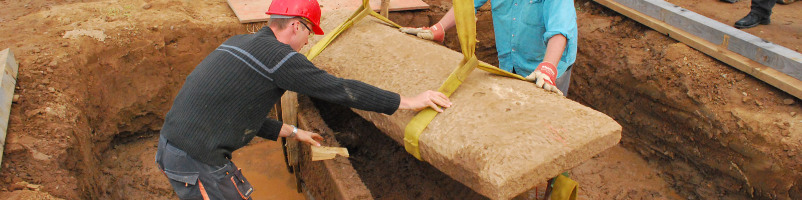 Archäologische Denkmalpflege Zwei Männer bergen einen Sarkophag