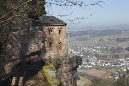 Sandsteinfelsen mit Klause Kastel, Bäume, im Tal ein Dorf