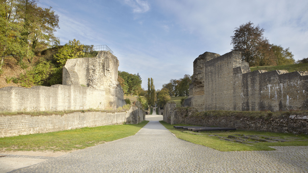 Gerader Weg der auf eine runde Fläche führt, Steinmauern zu beiden Seiten