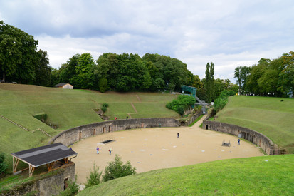 Runder Platz mit grasbewachsene Hängen